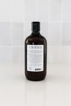 Load image into Gallery viewer, Bottle of dog shampoo with natural ingredients, sulphate and paraben free with spiced cucumber, lavender and tea-tree scent in a bathroom. Back label view.

