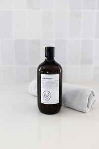 Bottle of dog shampoo with natural ingredients, sulphate and paraben free with spiced cucumber, lavender and tea-tree scent in a bathroom